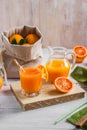 Glass of fresh pressed orange juice and blood oranges on wooden table. Bright summer mood. Top view Royalty Free Stock Photo