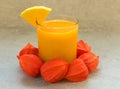 A glass of fresh pumpkin juice and pumpkin on a table decorated with physalis flowers. A concept of healthy seasonal smoothies and Royalty Free Stock Photo