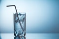 Glass of cold fresh sparkling mineral water on blue grandient background.