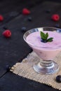 Glass of fresh strawberry and blueberry milkshake smoothie and fresh strawberries on pink black and wooden background Royalty Free Stock Photo