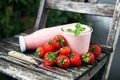 Glass of fresh strawberry shake, smoothie or milkshake and fresh strawberries on table. Healthy food and drink concept Royalty Free Stock Photo