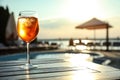 Glass of fresh summer cocktail on wooden table near swimming pool at sunset. Space for text Royalty Free Stock Photo