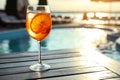 Glass of fresh summer cocktail on wooden table near swimming pool outdoors. Space for text Royalty Free Stock Photo