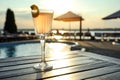 Glass of fresh summer cocktail on wooden table near swimming pool at sunset. Space for text Royalty Free Stock Photo