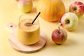 Glass of Fresh Tasty Pumpkin and Apples Juce or Smoothie with Cinnamon with Black Strew on Wooden Cutting Board Ripe Apples and