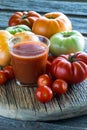 A glass of fresh tomato juice on a rustic board surrounded by various tomatoes. Royalty Free Stock Photo