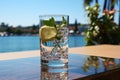 Glass of fresh water on light grey table outdoors, closeup