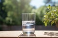 Glass of fresh water on light grey table outdoors, closeup