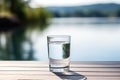 Glass of fresh water on light grey table outdoors, closeup