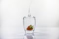 Glass of fresh water with strawberry dipped in causing a splash Royalty Free Stock Photo