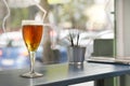 A glass of freshly drafted beer on a tall wooden table