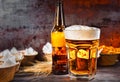 Glass with freshly poured beer and head of foam near bottle and Royalty Free Stock Photo