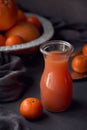 Glass of freshly squeezed grapefruit juice with fresh citrus fruits on dark background. Royalty Free Stock Photo