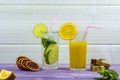 A glass of sweet freshly squeezed orange juice and a glass of Mojito with ice. Sprig of mint and orange slices Royalty Free Stock Photo