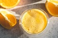 A glass of freshly squeezed orange juice and oranges on the kitchen table. Royalty Free Stock Photo