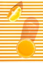 Glass of freshly squeezed orange juice with pulp fruit wedge on duotone yellow and white striped background. Summer fitness Royalty Free Stock Photo