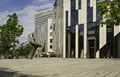 Glass fronted buildings beside a large model nail diagonally inserted in the ground in Dusseldorf, Germany.