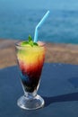 A glass of frozen fruit slush granita drink on the table by the sea. Royalty Free Stock Photo