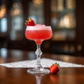 Glass of frozen strawberry margarita garnished with a salt rim and a lime slice in restaurant. Margarita with crushed ice. Red Royalty Free Stock Photo