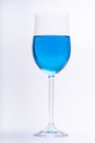 Glass full of blue liquid, water on white background