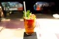 Glass full  famous british classic Pimm`s cocktail with green mint leaves indoor on bar top with straw Royalty Free Stock Photo