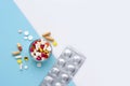 A glass full of pills, tablets, capsules on blue and white background, with empty space for text. Top view Royalty Free Stock Photo