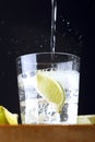 Glass of gin tonic with lime and tonic falling Royalty Free Stock Photo