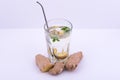 Glass of ginger tea on white background