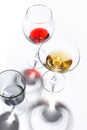 Glass glasses with drinks of different colors on a white background. Top view. The concept of an alcoholic cocktail Royalty Free Stock Photo