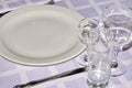 Crockery. Glass glasses, wine glasses, glasses, plates standing on a white tablecloth and reflecting light glare.