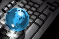 Glass globe on computer keyboard Royalty Free Stock Photo