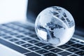 Glass globe on laptop computer background