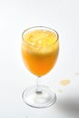 Glass goblet with bubbling orange liquid on a white background.