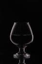 Glass goblet with drink on black background