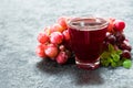 Glass of grape juice and a branch of grapes. Close-up.