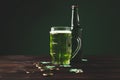 glass of green beer with shamrock and golden coins on table st patricks