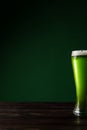 glass of green beer on wooden table st patricks