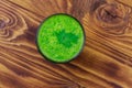 Glass of green detox smoothie of cucumber and parsley on wooden table. Top view