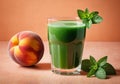 A glass of green fresh juice with fresh mint leaves and peach on a peach textured background. Daytime sunny soft Royalty Free Stock Photo