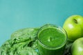 Glass with Green Fresh Raw Smoothie from Leafy Greens Vegetables Fruits Apples Bananas Kiwi on Scattered Spinach Leaves Royalty Free Stock Photo