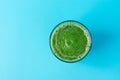 Glass with Green Fresh Raw Smoothie from Leafy Greens Vegetables Spinach Fruits Apples Bananas Kiwi on Mint Blue Background Royalty Free Stock Photo