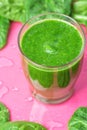 Glass with Green Fresh Smoothie from Leafy Greens Vegetables Fruits. Apples Bananas Kiwi Zucchini Spinach Leaves Pink Background Royalty Free Stock Photo