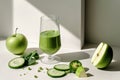 A glass of green juice is on a table with a green apple and cucumber slices Royalty Free Stock Photo