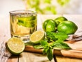 Glass with green lime drink and mint on napkin.