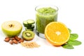 Glass of green smoothie with fresh apple, orange halves, sliced cucumber, spinach leaves, almonds and pine nuts Royalty Free Stock Photo
