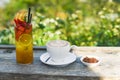 Glass of green tropical tea with lime, orange, watermelon and apple against green and cappuccino with brown sugar Royalty Free Stock Photo