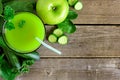 Glass of green vegetable juice, downward view on rustic wood