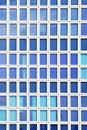 Glass blue square Windows of facade modern city business building skyscraper. Modern apartment buildings in new neighborhood. Royalty Free Stock Photo