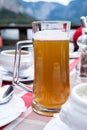 A glass of Hallstatt local beer on the table at a romantic restaurant beside the Hallstattersee Lake in High Alps Mountains, a Royalty Free Stock Photo