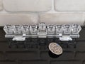 A glass Hannuka and silver dreidel on a black piano with stone wall in the background Royalty Free Stock Photo